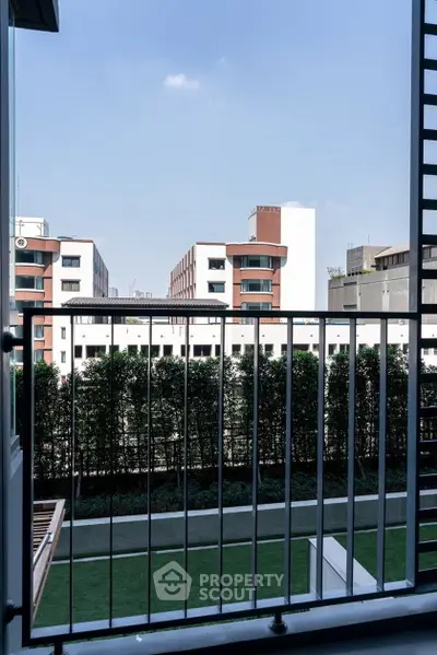 Modern apartment balcony with city view and lush greenery