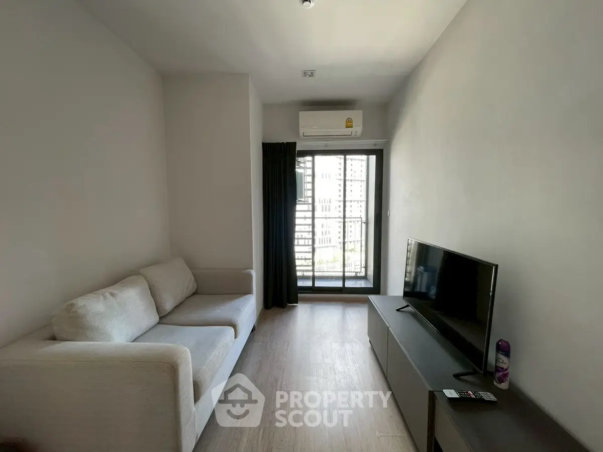 Modern living room with sleek furniture and city view balcony, perfect for urban living.