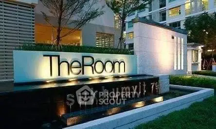 Modern building entrance with illuminated signage at The Room Sukhumvit 79.
