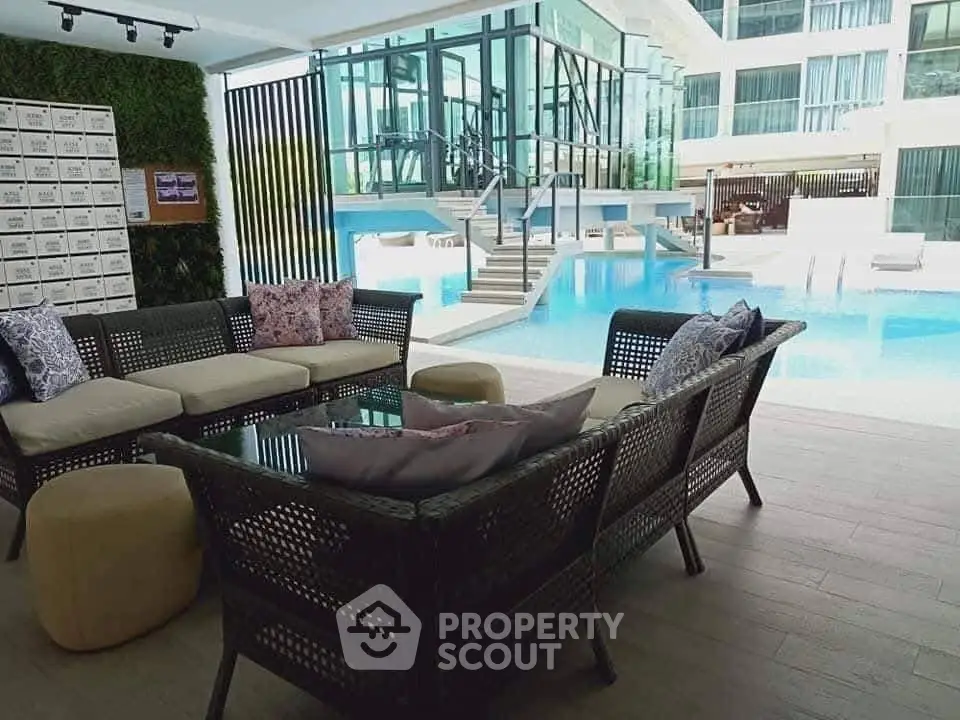 Luxurious poolside lounge with modern seating and stunning glass architecture.