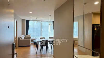 Spacious modern living room with dining area and large windows in a stylish apartment.