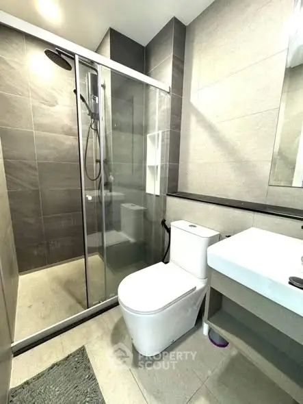 Modern bathroom with glass shower and sleek fixtures in contemporary design.