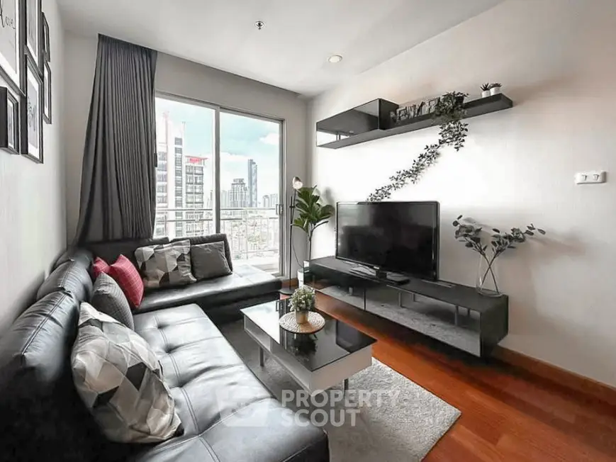 Modern living room with city view, stylish decor, and sleek furniture in a high-rise apartment.