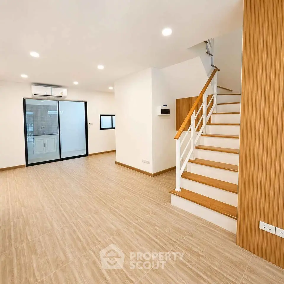 Spacious modern living room with wooden staircase and open layout