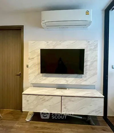 Modern living room with sleek TV setup and air conditioning unit