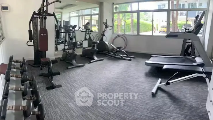 Modern gym with state-of-the-art equipment and large windows for natural light.