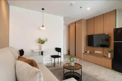 Modern living room with stylish decor and wall-mounted TV in a cozy apartment.