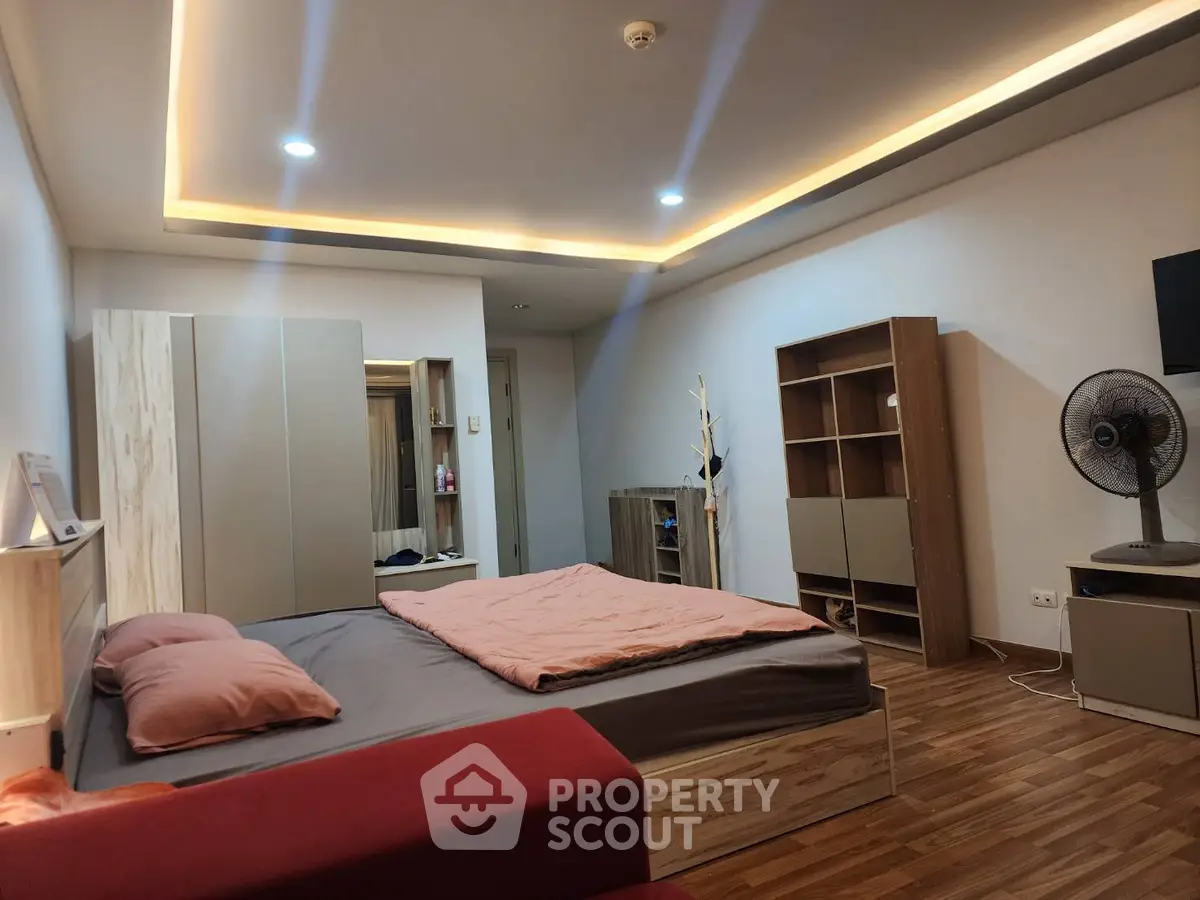 Spacious modern bedroom with stylish furniture and ambient lighting