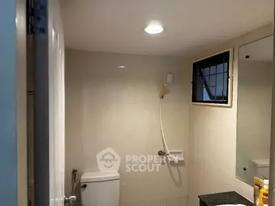 Modern bathroom with shower and toilet in a sleek minimalist design.