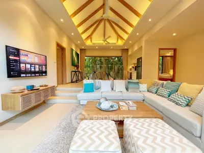 Luxurious living room with vaulted ceiling, modern decor, and large sectional sofa in tropical villa.