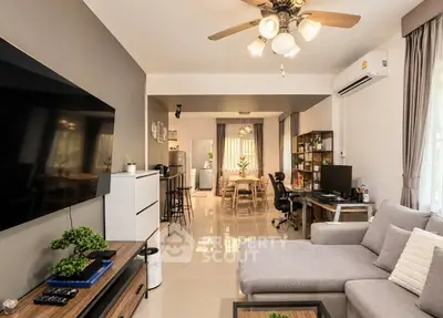 Spacious living room with modern decor and open layout, featuring a cozy sectional sofa and stylish lighting.