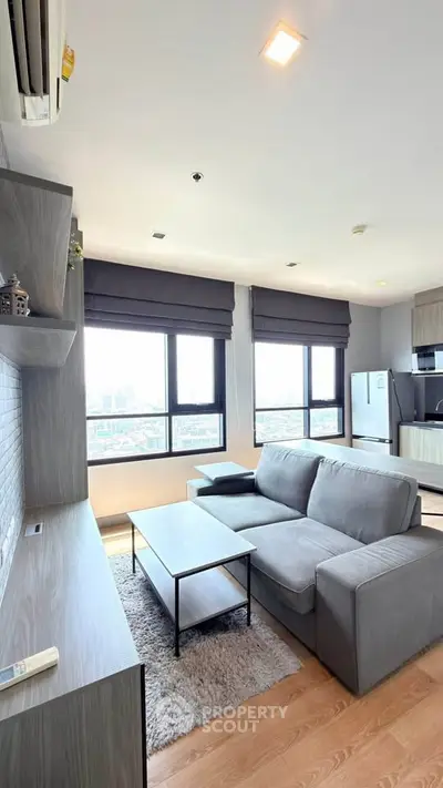 Modern living room with large windows and stylish furniture in a high-rise apartment.