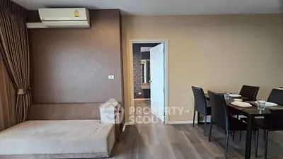 Modern living room with dining area, featuring sleek furniture and stylish decor.