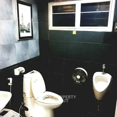 Modern bathroom with sleek black tiles and contemporary fixtures.