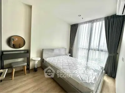 Modern bedroom with large window and minimalist decor in a high-rise apartment.