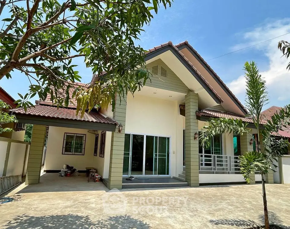 Charming single-story house with spacious driveway and lush greenery, perfect for family living.