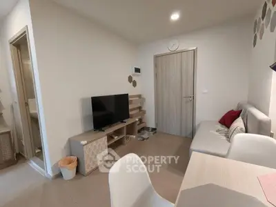 Modern living room with stylish furniture and TV in a cozy apartment setting.