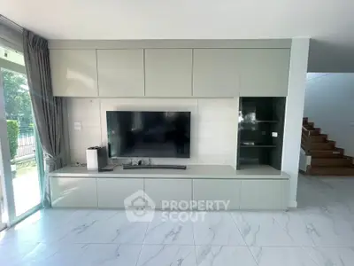 Modern living room with sleek built-in TV unit and natural light