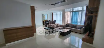 Spacious modern living room with elegant furniture and large windows offering natural light.