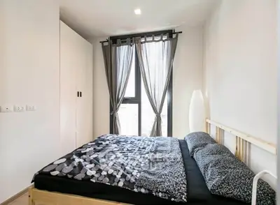 Modern bedroom with stylish decor and large window for natural light.