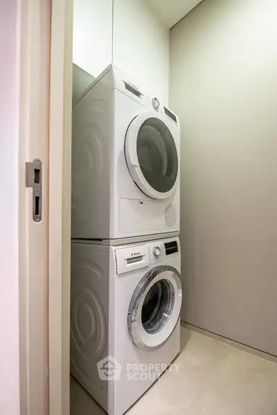 Modern laundry area with stacked washer and dryer in sleek design.