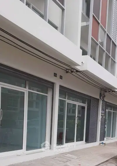 Modern commercial building exterior with large glass windows and sleek design.