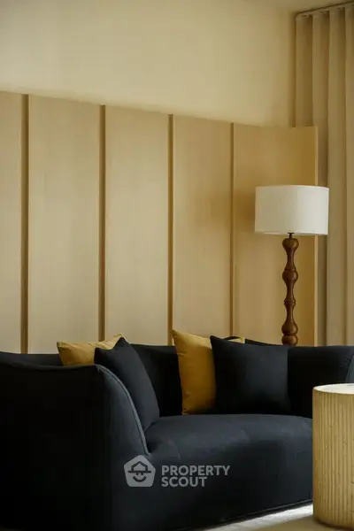 Elegant living room with modern black sofa and stylish floor lamp