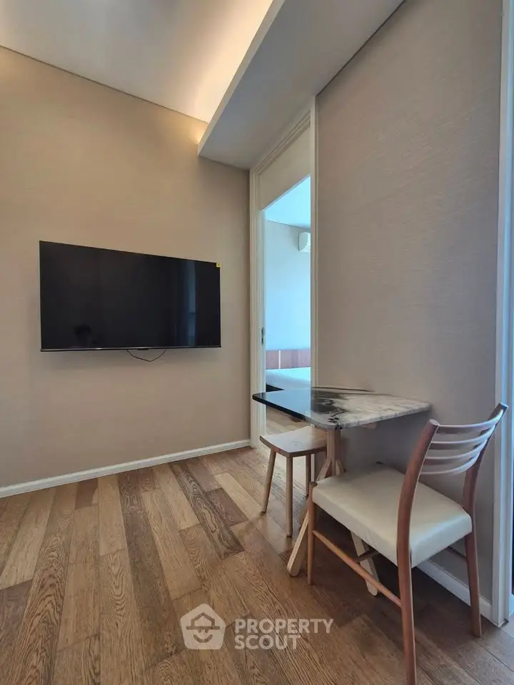 Modern interior with wall-mounted TV and stylish dining area in a cozy apartment.