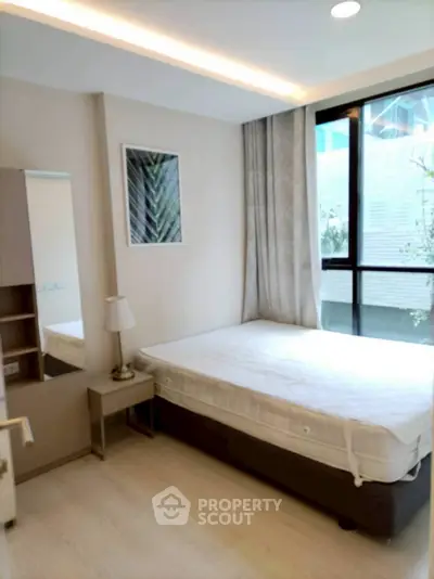 Modern bedroom with large window and minimalist decor in urban apartment
