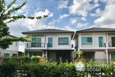 Charming suburban two-story house with lush greenery and modern design.