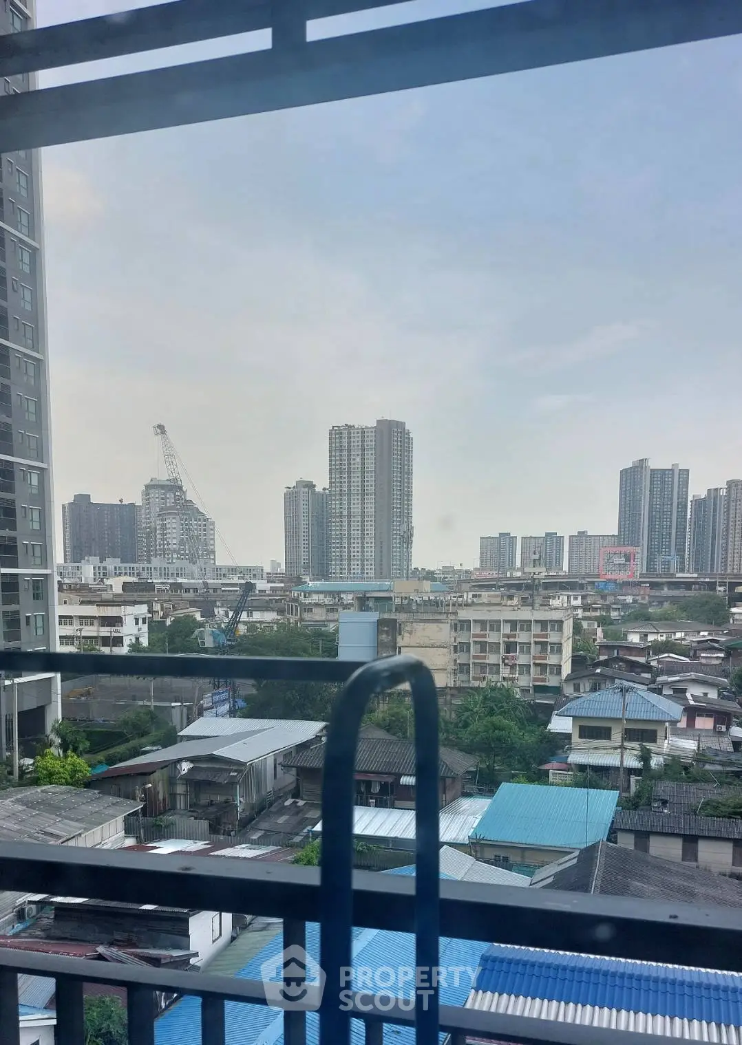 Stunning cityscape view from high-rise apartment balcony showcasing urban skyline.