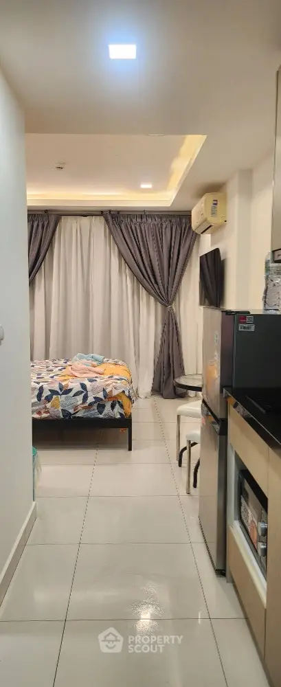 Modern studio apartment with cozy bedroom and compact kitchen