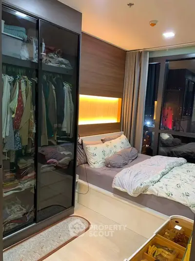 Cozy bedroom with modern wardrobe and ambient lighting in a stylish apartment.
