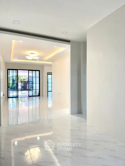 Spacious modern living room with glossy marble flooring and large windows.