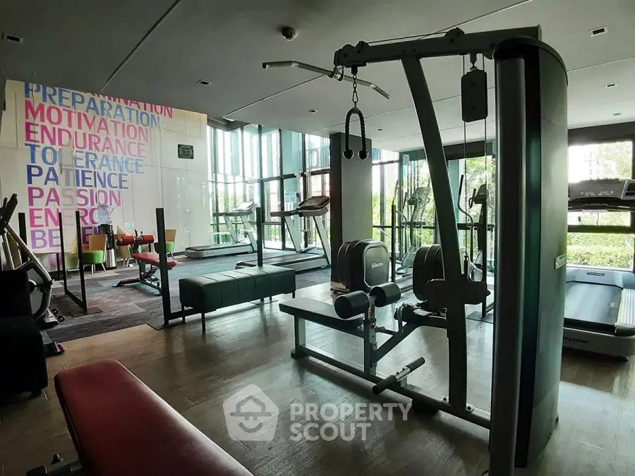Modern gym with state-of-the-art equipment and motivational wall art in a luxury residential building.