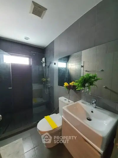 Modern bathroom with sleek design, featuring a glass shower and stylish fixtures.