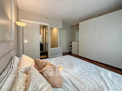 Spacious bedroom with modern design and ample storage in a stylish apartment.