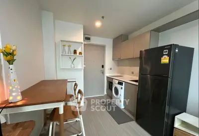 Modern kitchen with sleek appliances and cozy dining area in a stylish apartment.