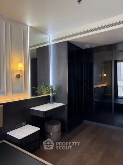Luxurious modern bedroom with elegant lighting and sleek dark wood finishes.
