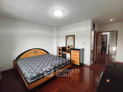 Spacious bedroom with modern furniture and hardwood flooring
