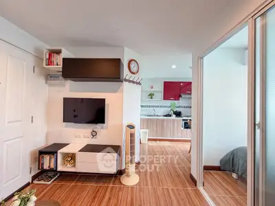 Modern open-layout living room with stylish kitchen and cozy bedroom in view.