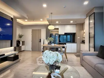 Modern open-plan living room with stylish decor and sleek kitchen area.