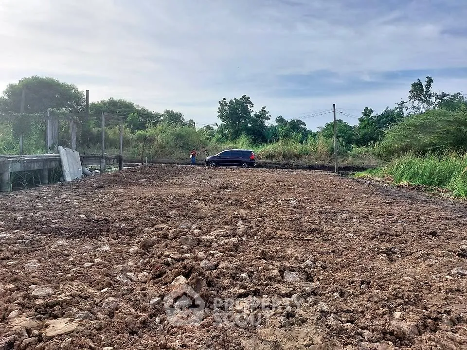 Expansive land plot ideal for development with lush greenery and clear skies.