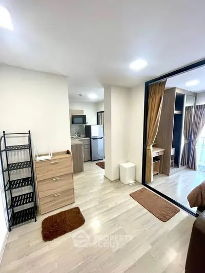 Modern apartment interior with open layout, featuring a compact kitchen and cozy living area.