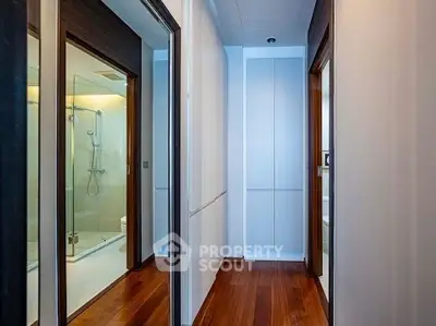 Modern apartment hallway with wooden flooring and glass shower enclosure