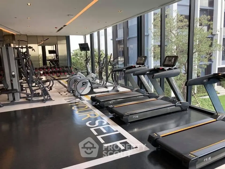 Modern gym with state-of-the-art equipment and floor-to-ceiling windows offering a scenic view.