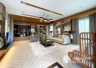 Expansive living room with elegant wooden accents and open layout leading to a modern kitchen, bathed in natural light from floor-to-ceiling windows, perfect for entertaining.