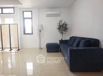 Spacious living room with modern blue sofa and natural light