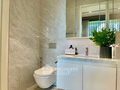 Luxurious modern bathroom with marble walls and sleek fixtures, perfect for a sophisticated home.