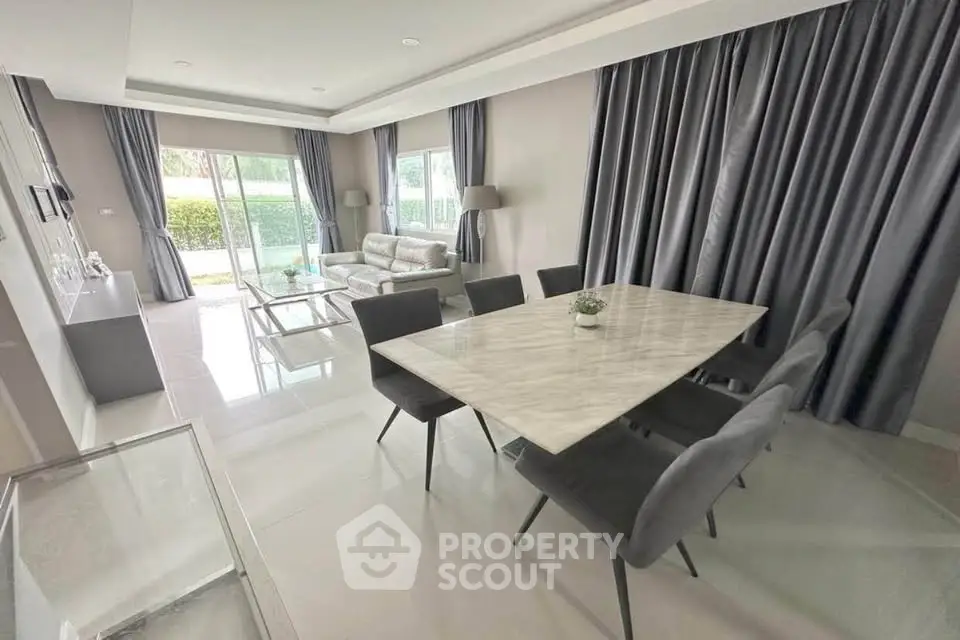 Modern living room with elegant dining area and large windows